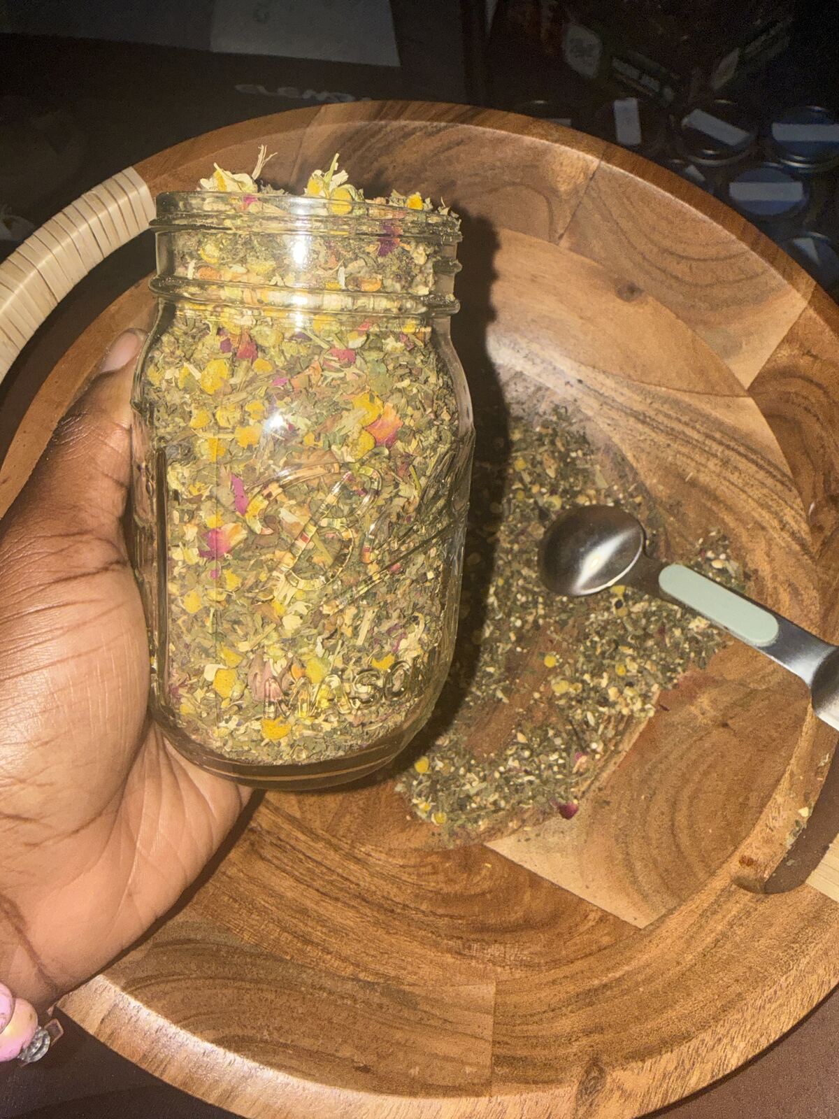 Herbs and roots arranged on deep forest green surface